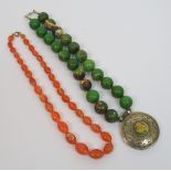 An agate necklace with twenty two beads and with white metal pendant medallion, 27cm long and an