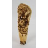 A Japanese carved ivory cane handle decorated with a lion attacking a tiger, signed, 12cm long