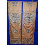 A pair of Chinese silk embroidered panels decorated with blue and cream meandering flowers and