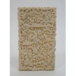 A Cantonese export ivory card case carved allover with numerous figures amongst dense foliage and