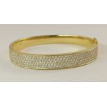 An 18ct yellow gold diamond set bangle the front portion pave set with estimated approximately 2.