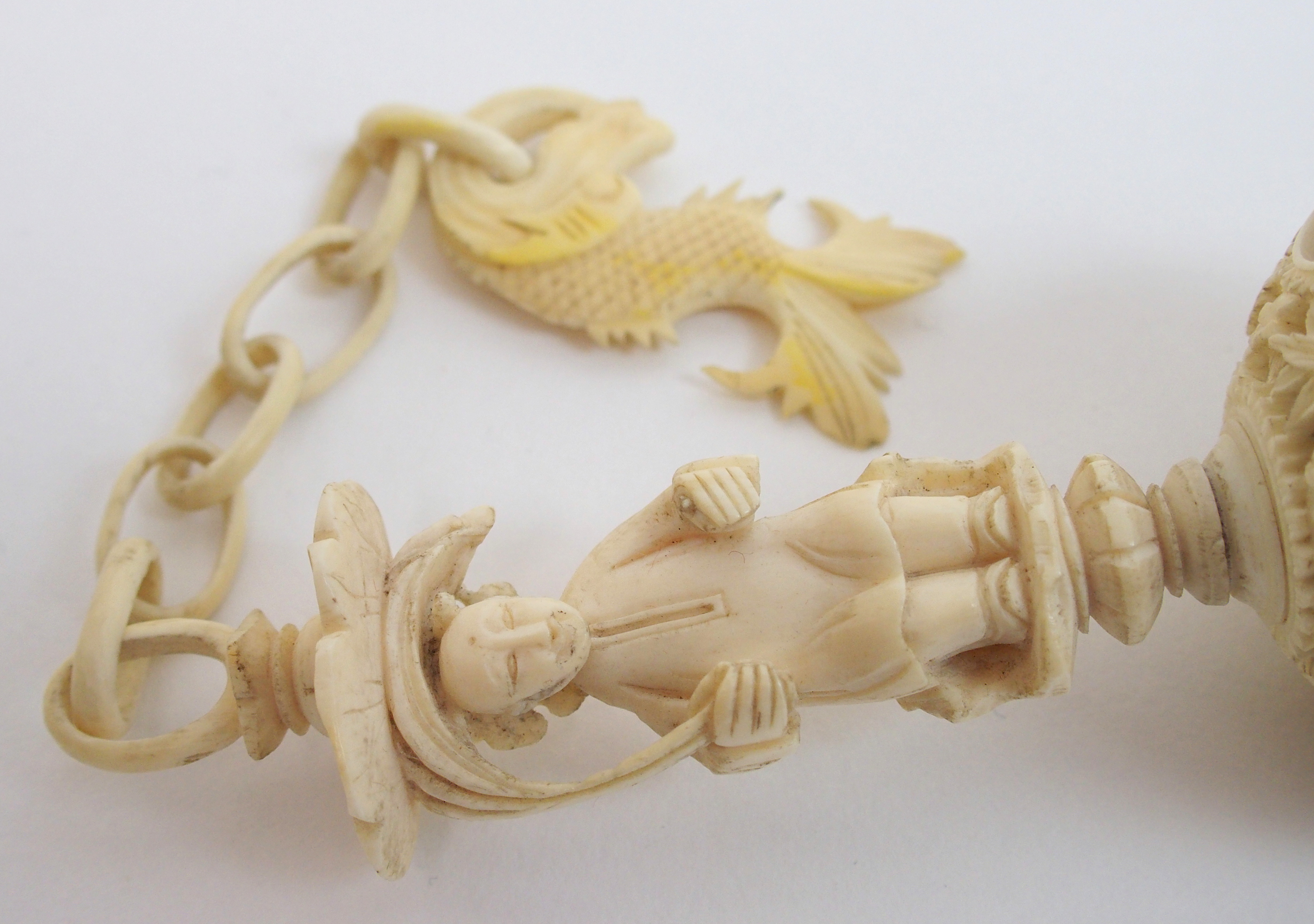 A Cantonese ivory concentric ball carved with dolphin and chain suspension attached to a figure - Bild 9 aus 10