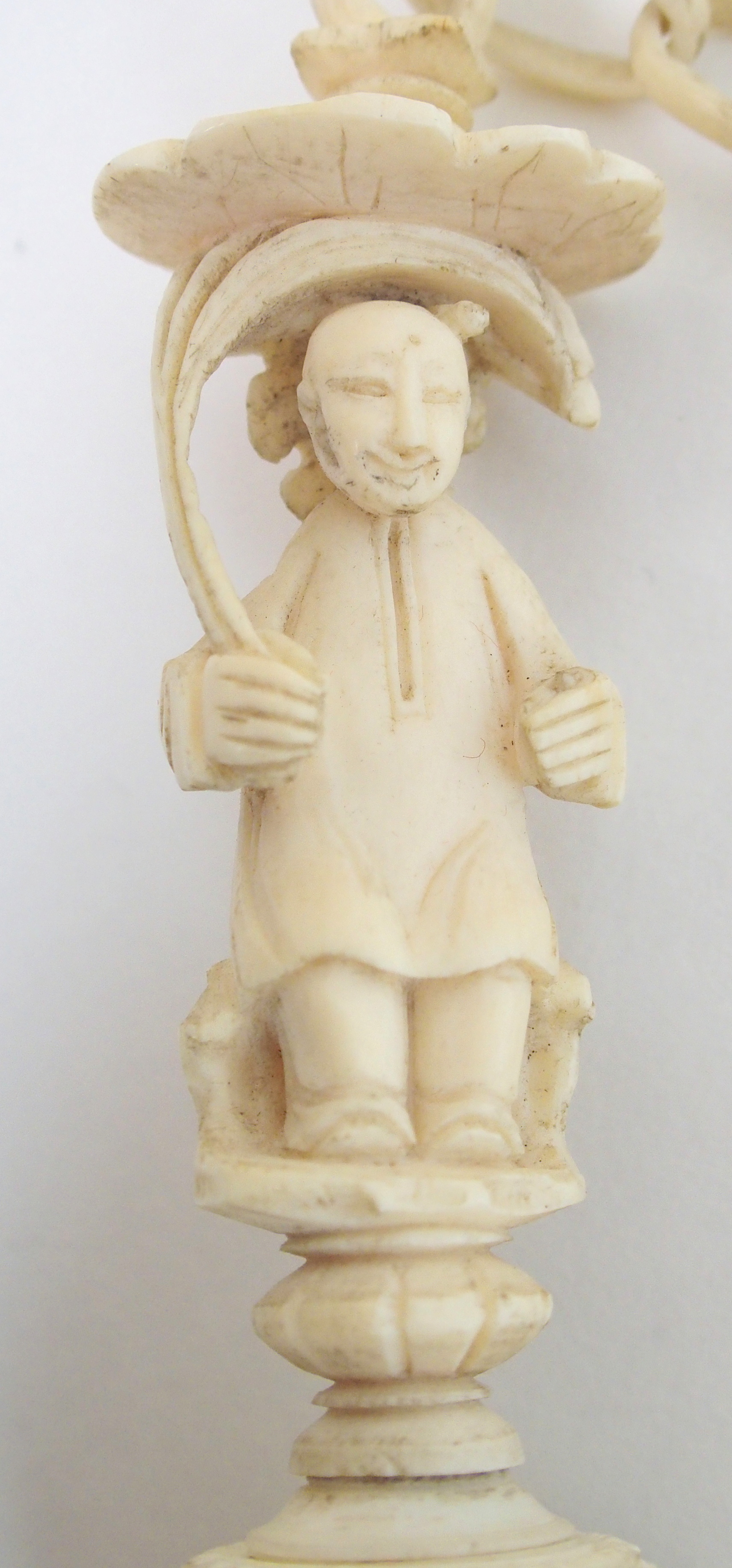 A Cantonese ivory concentric ball carved with dolphin and chain suspension attached to a figure - Bild 2 aus 10