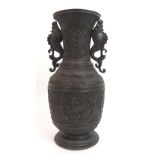 A Chinese bronze two-handled vase cast with dragons and applied with scrolling sea creature handles,