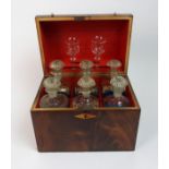 A 19th century flame mahogany decanter box the dome front opening to reveal six decanters with