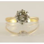 A 1.12ct diamond solitaire ring with classic crown mount in white metal with a tapered yellow