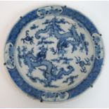 A Chinese blue and white crackled glaze dish painted with two confronting dragons within a diaper