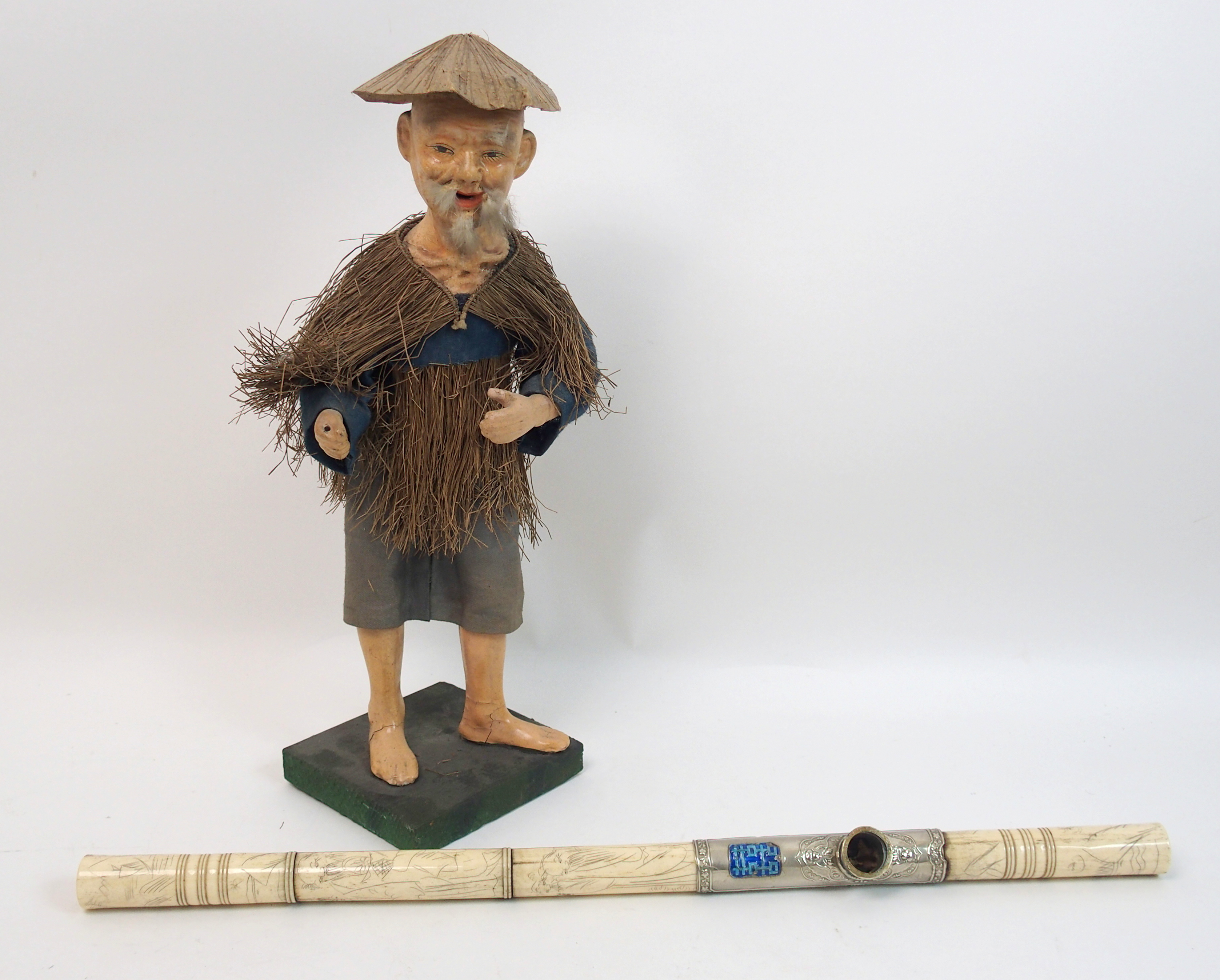 A Chinese papier mache figure of a worker with straw cape and linen costume, 37cm high and a