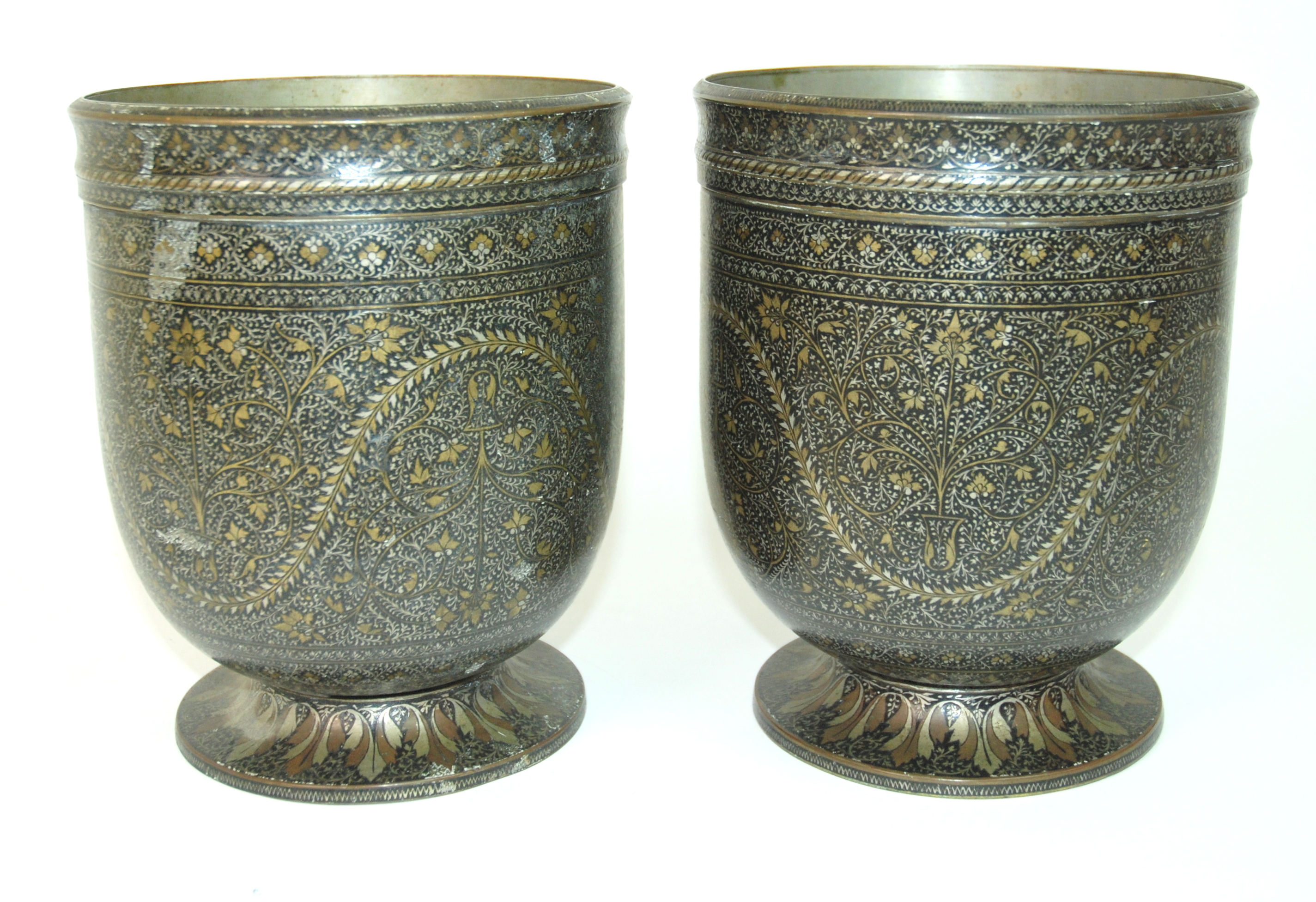 A pair of Kashmiri metal jardinieres decorated with meandering foliage within bands of