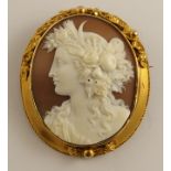 A well carved cameo in a bright yellow metal brooch mount depicting a maiden in profile with a