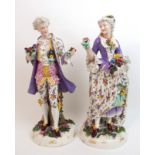 A pair of continental porcelain figures modelled as a lady and gentleman in 18th Century attire,