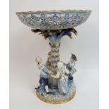 A Meissen porcelain centrepiece modelled with children dancing around a palm tree, supporting a