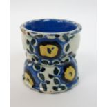 Jessie M King (1875-1949) A pottery egg cup of waisted form, hand painted in blues and yellow with