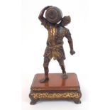 A Japanese bronze figure of a man carrying a tied bale on his shoulder, wearing floral patterned