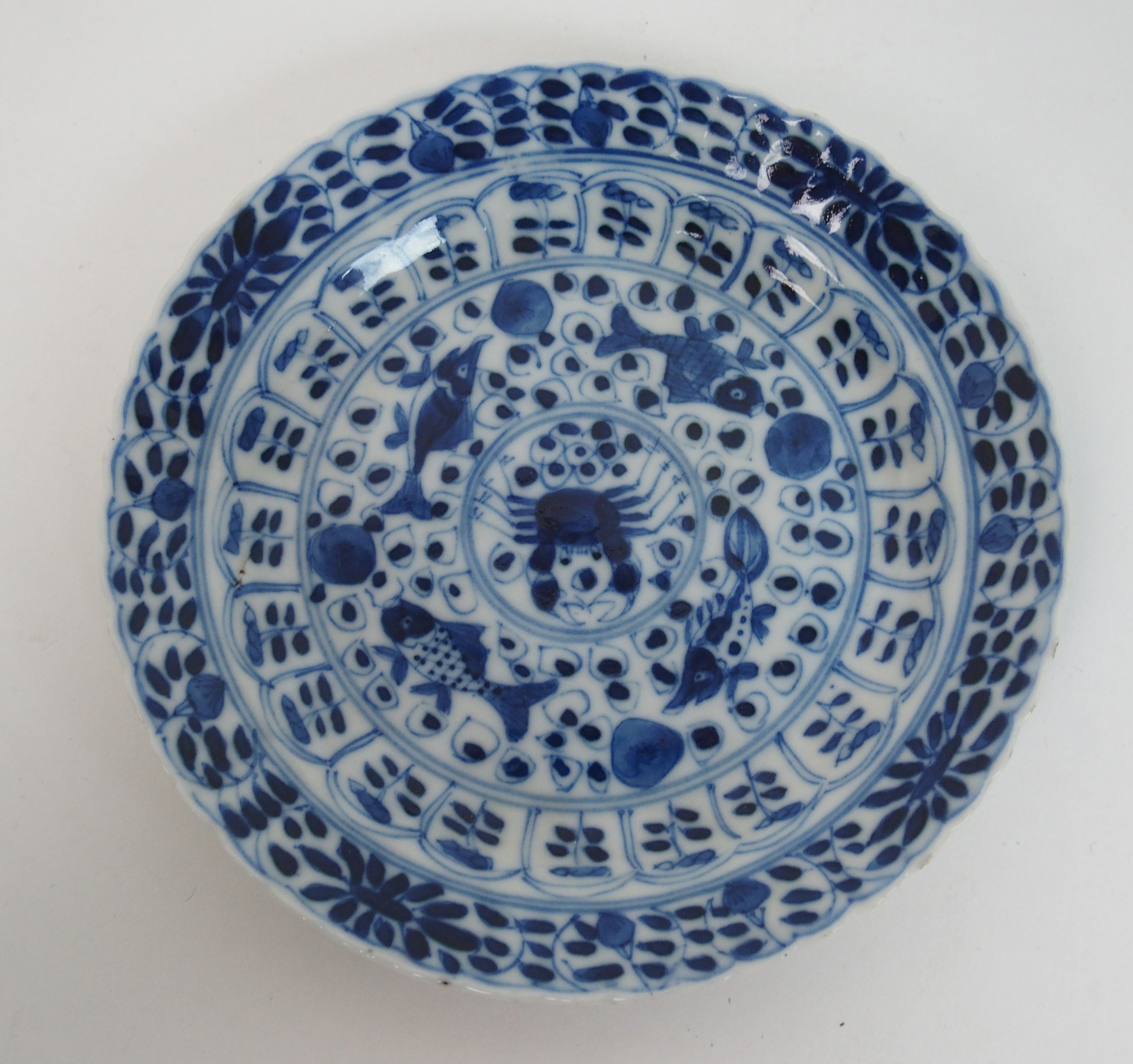 A Chinese blue and white tea bowl and saucer painted with fish surrounding a crab amongst foliage, - Bild 3 aus 10