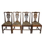 A set of twelve mahogany Chippendale style dining chairs with pierced vase shaped back splats