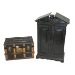 A Victorian ebonised oak miniature cabinet with a pair of carved doors enclosing two short and three