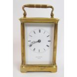 A French brass carriage clock plain white enamel dial with Roman numerals, signed J W Benson,