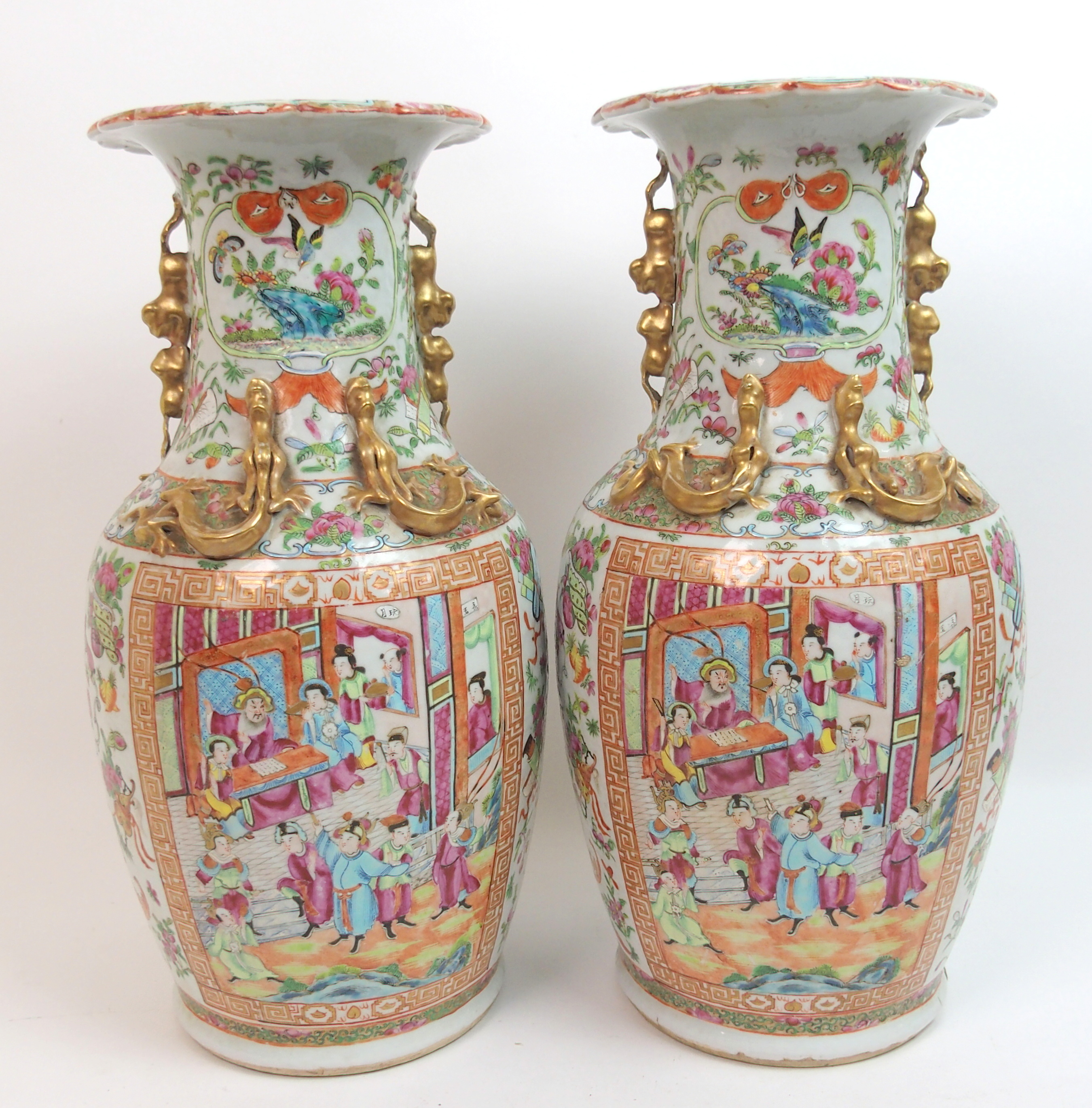 A pair of Canton famille rose baluster vases panted with large panels of mandarins holding court