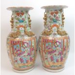 A pair of Canton famille rose baluster vases panted with large panels of mandarins holding court