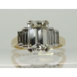 An 18ct gold emerald cut and baguette cut diamond ring the central emerald cut measures 9.19mm x 6.