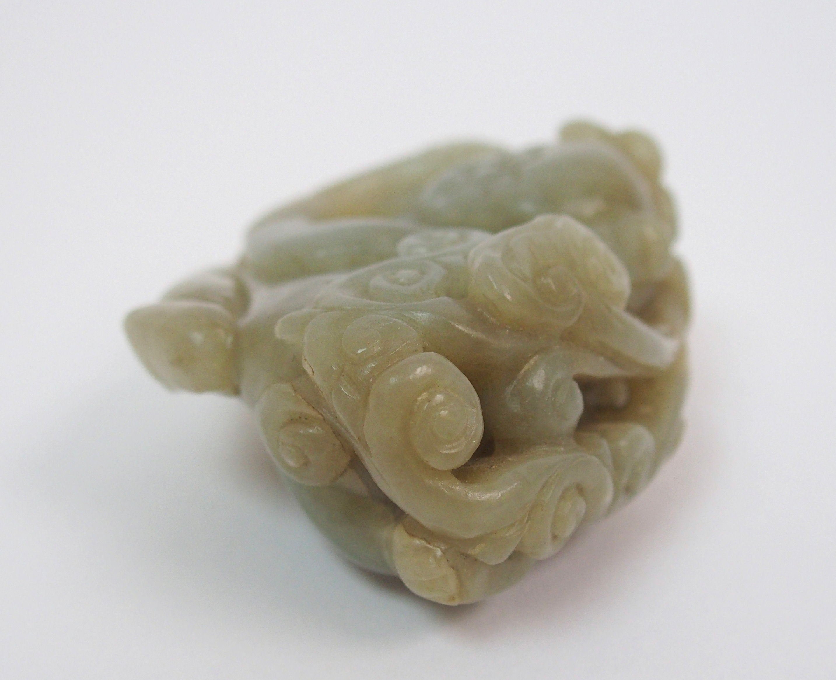 A Chinese jade carving of a child lying and holding lingzhi frond, 7cm wide - Image 6 of 10