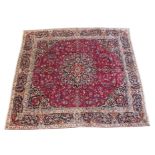 A red ground meshed rug with blue central medallion, 287cm x 321cm