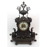 A French patinated cast metal mantle clock the cream enamel dial with Roman numerals and central