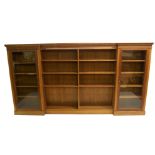 *WITHDRAWN* An Edwardian oak breakfront display bookcase the centre section flanked by a door either