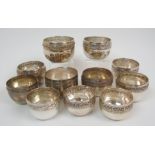 Eleven Eastern white metal bowls decorated with bands of scrolling foliage, ranging in size from 7.