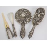 A Chinese export white metal hand mirror, hair brush, shoe horn and glove stretchers decorated