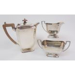 An Art Deco silver three piece tea service by Henry Clifford Davies, Birmingham 1933, the teapot