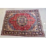 A red ground meshed rug with blue central medallion and border, 370cm x 282cm