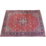 A red ground Sarough rug with blue central medallion and border, 287cm x 387cm