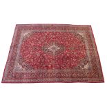 A red ground Kashan rug with blue central medallion and borders, 290cm x 386cm