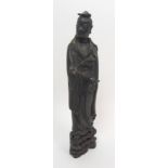 A Chinese bronze figure of a Lohan standing and wearing long draped robes, with one hand pointing