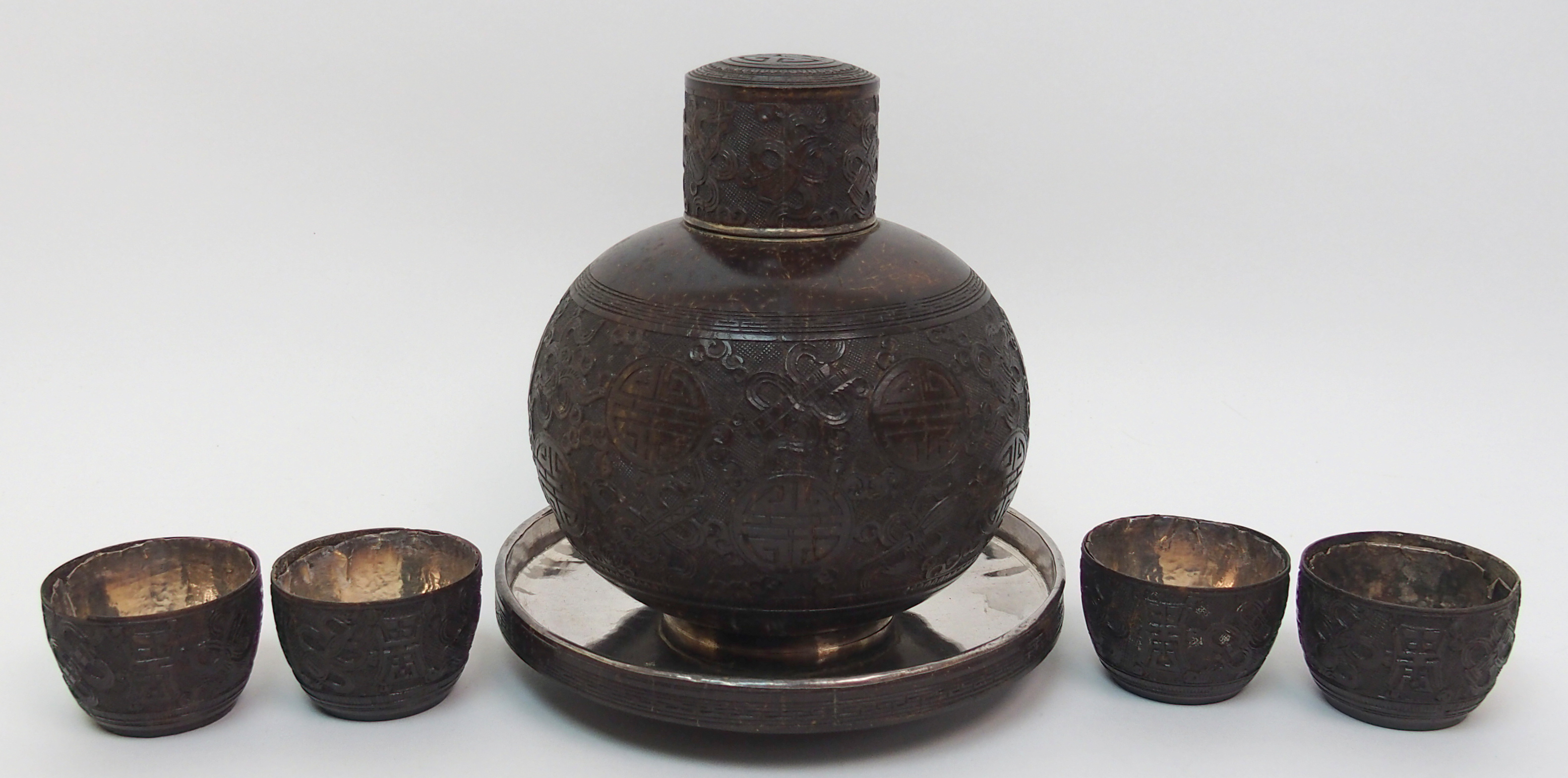 A Chinese coconut and silver mounted set comprising; bottle decanter and stopper, 15cm high,