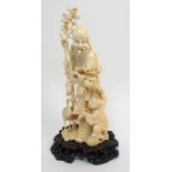 A Chinese carved ivory figure of Shou Lao standing with devotee, stork and bat, holding a staff