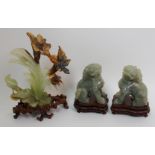 A Chinese pair of carved hardstone kylin seated on all fours, with carved wood stands and silk case,