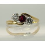 An 18ct gold garnet and diamond three stone ring in a twist design, diamonds estimated approx 0.