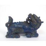 A Chinese lapis lazuli dragon recumbent with head turned towards its tail (minor chips), 8cm long