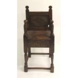 An 18th Century style oak high chair with carved panels to front and sides, 98cm tall
