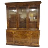A Victorian walnut display bookcase the moulded over-hanging cornice above three doors enclosing