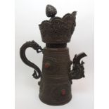 A Tibetan copper ewer decorated all over with foliage and masks, with raised medallions of Ganesh,