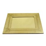 A Glasgow style Arts and Crafts white metal framed mirror with relief decoration of Celtic