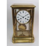 A late 19th century French brass cased four glass mantel clock the white enamel dial with black