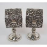 A pair of Chinese white metal napkin rings each decorated with figures, fish and buildings