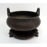 A Chinese bronze censer with lug handles, tripod base and cast with six character seal mark, 15cm
