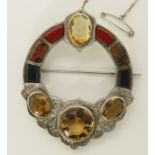 A large Scottish agate brooch also set with citrines with engraved detail to the white metal body,