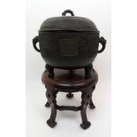 A Chinese bronze censer and cover cast with a broad band of waves divided by a panel of calligraphy,